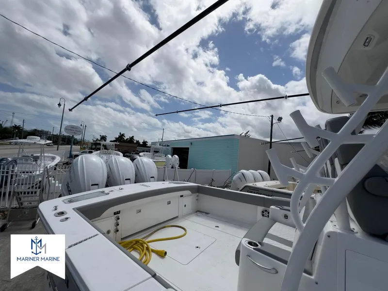 Slide: The Image of 2024 Regulator 37 boat deck with seating, docked at Mariner Marine under a partly cloudy sky. - 8