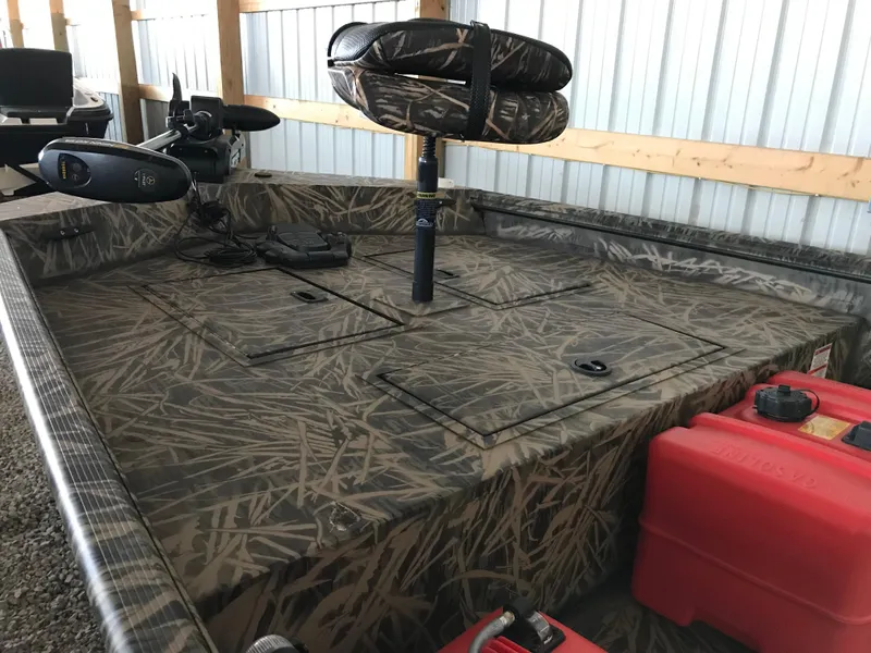 Slide: The Image of 2022 Crestliner 1760 Retriever Jon boat interior with camo pattern and storage compartments. - 5