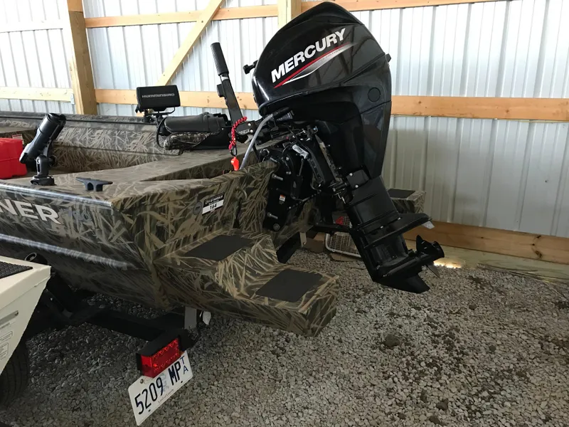 Slide: The Image of 2022 Crestliner 1760 Retriever Jon boat with Mercury outboard motor in storage. - 7