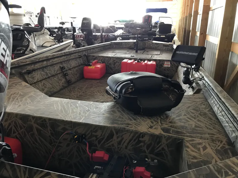Slide: The Image of 2022 Crestliner 1760 Retriever Jon boat interior with camo design and fishing equipment. - 9