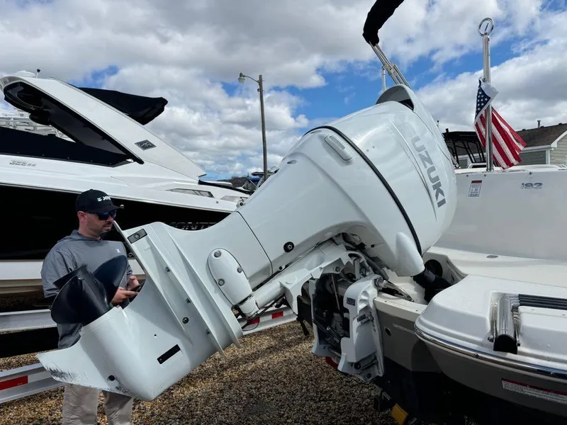 Slide: The Image of 2022 Stingray 192 SC boat with Suzuki outboard motor, man inspecting. - 10