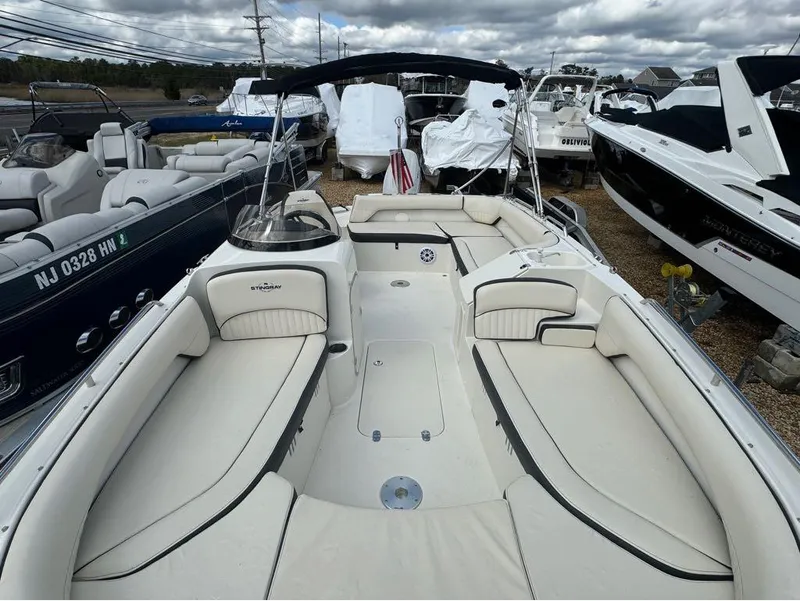 Slide: The Image of 2022 Stingray 192 SC boat with spacious seating, docked among other boats. - 3
