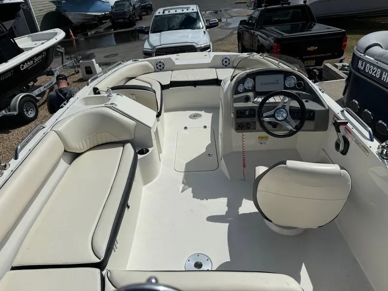 Slide: The Image of 2022 Stingray 192 SC boat interior with beige seating and modern dashboard. - 9