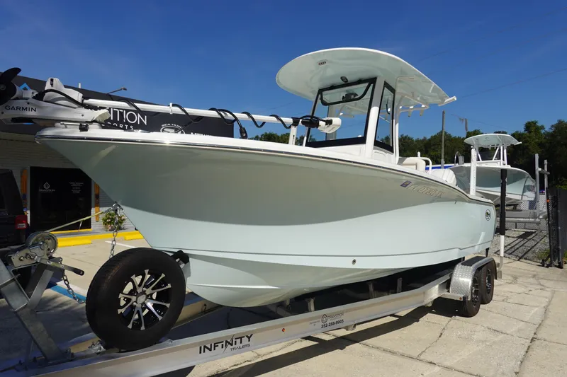 Slide: The Image of 2025 Sea Hunt Ultra 239 SE boat on trailer, displayed outdoors under clear blue sky. - 1