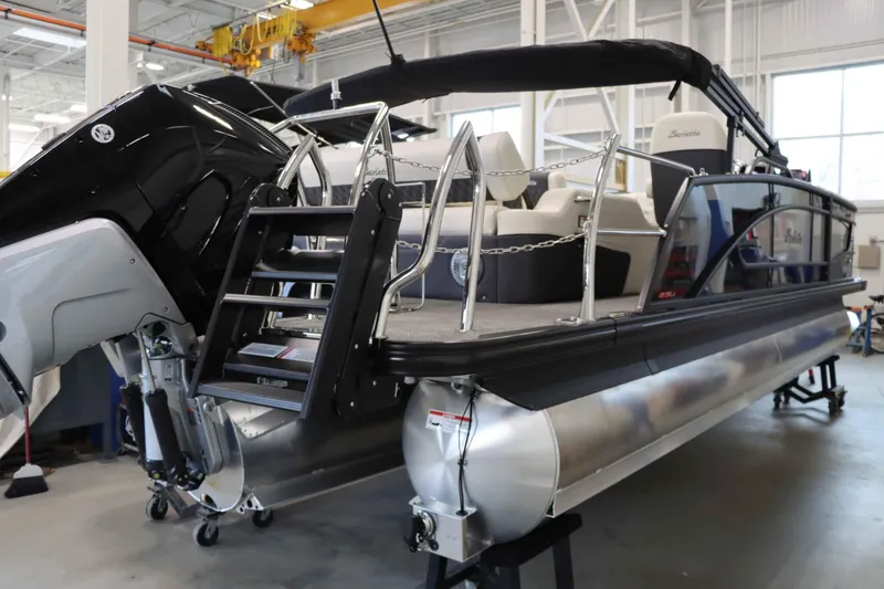Slide: The Image of 2025 Barletta Lusso 23U pontoon boat in a showroom, showcasing sleek design and modern features. - 1