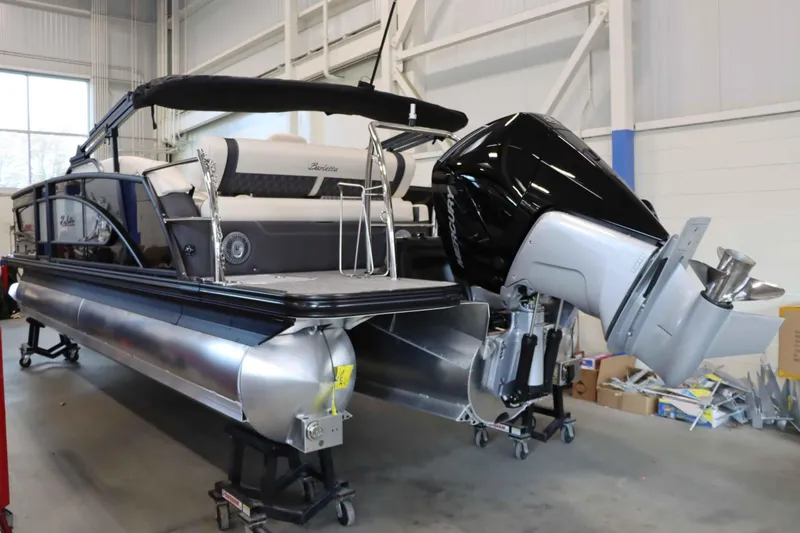 Slide: The Image of 2025 Barletta Lusso 23U pontoon boat with Mercury outboard motor in a showroom. - 3