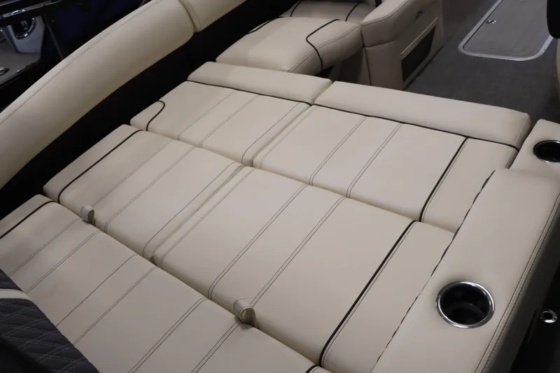 Slide: The Image of 2025 Barletta Lusso 23U boat interior with beige leather seating and cup holders. - 5