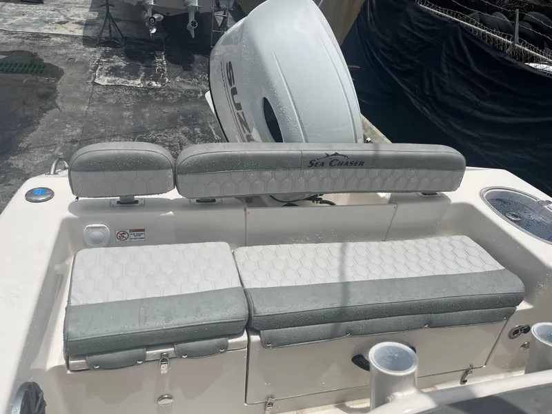 Slide: The Image of 2025 Sea Chaser 22 HFC boat with cushioned seating and outboard motor. - 15