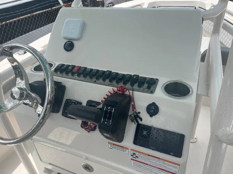 Slide: The Image of Control console of a 2025 Sea Chaser 22 HFC boat with steering wheel and switches. - 17