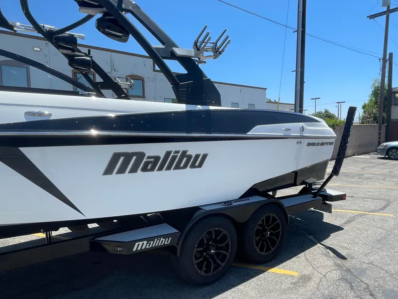 Slide: The Image of 2017 Malibu Wakesetter 25 LSV boat on a trailer in a parking lot. - 2