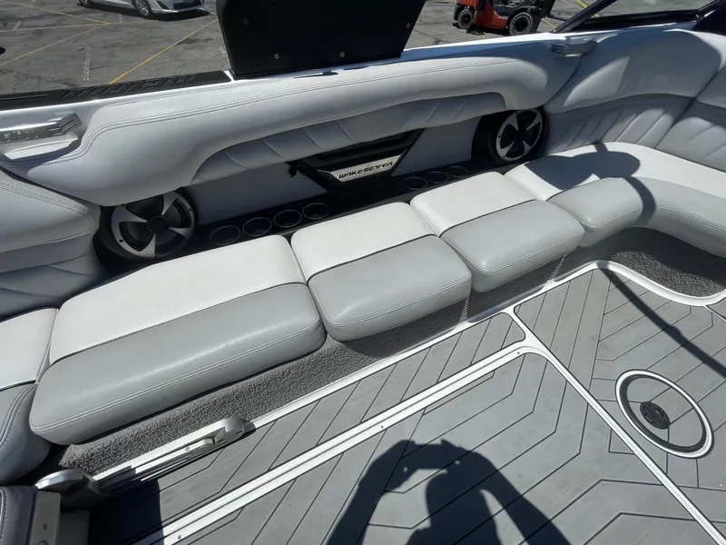 Slide: The Image of 2017 Malibu Wakesetter 25 LSV interior seating with gray upholstery and built-in speakers. - 8