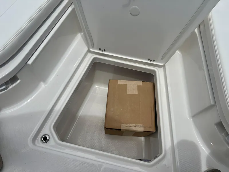 Slide: The Image of Storage compartment of 2025 Robalo 266 Cayman SD boat with a cardboard box inside. - 33