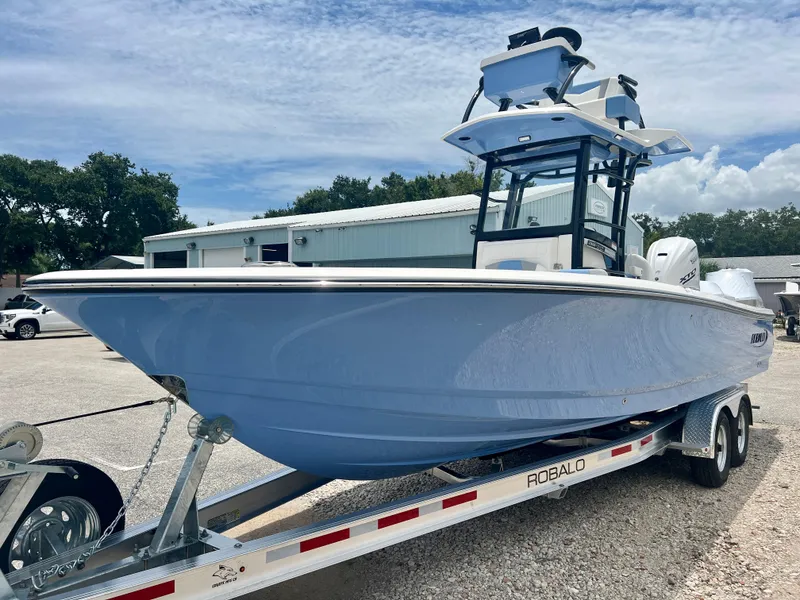 Slide: The Image of 2025 Robalo 266 Cayman SD boat on a trailer in a parking lot. - 4