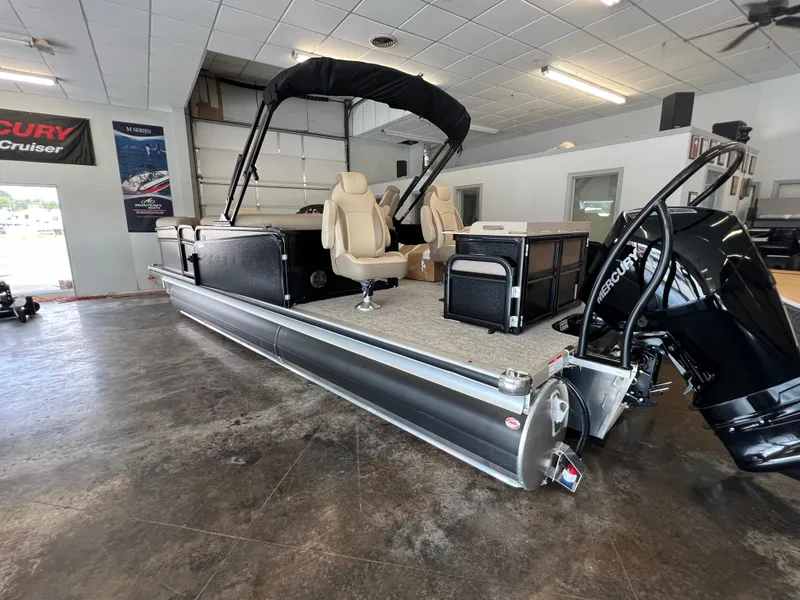 Slide: The Image of 2025 Premier Sunsation 230 Angler pontoon boat in showroom with Mercury outboard motor. - 4