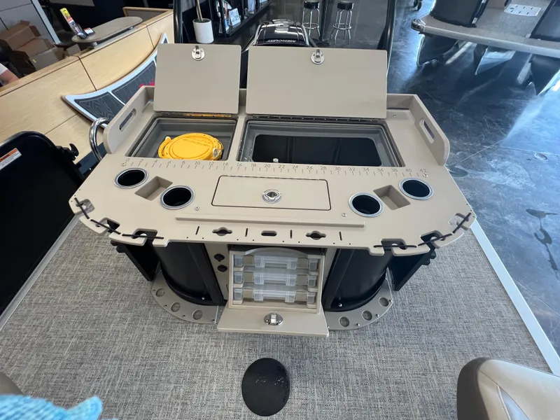 Slide: The Image of 2025 Premier Sunsation 230 Angler boat with open storage compartments and cup holders. - 8