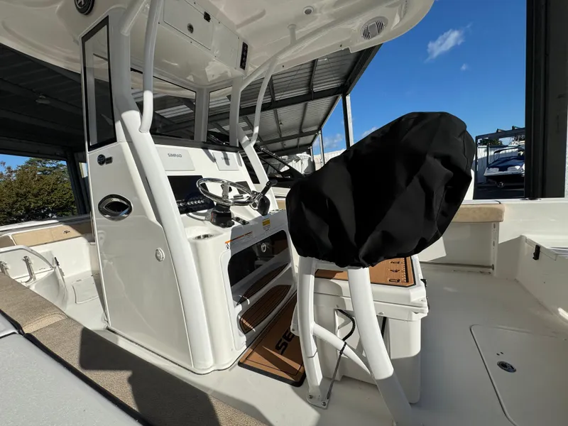 Slide: The Image of 2025 Sea Pro 242 Center Console boat interior, featuring helm and seating under a canopy. - 5