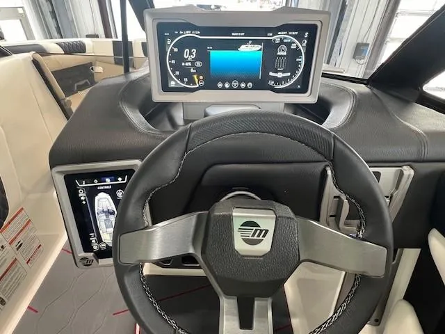Slide: The Image of 2024 Malibu M220 boat dashboard with steering wheel and digital display. - 11