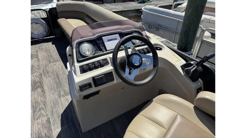 Slide: The Image of 2020 Godfrey SWEETWATER 2286 MT boat dashboard with steering wheel and controls. - 2