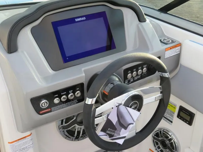 Slide: The Image of 2024 Chaparral 21 Surf boat dashboard with Simrad display and steering wheel. - 10