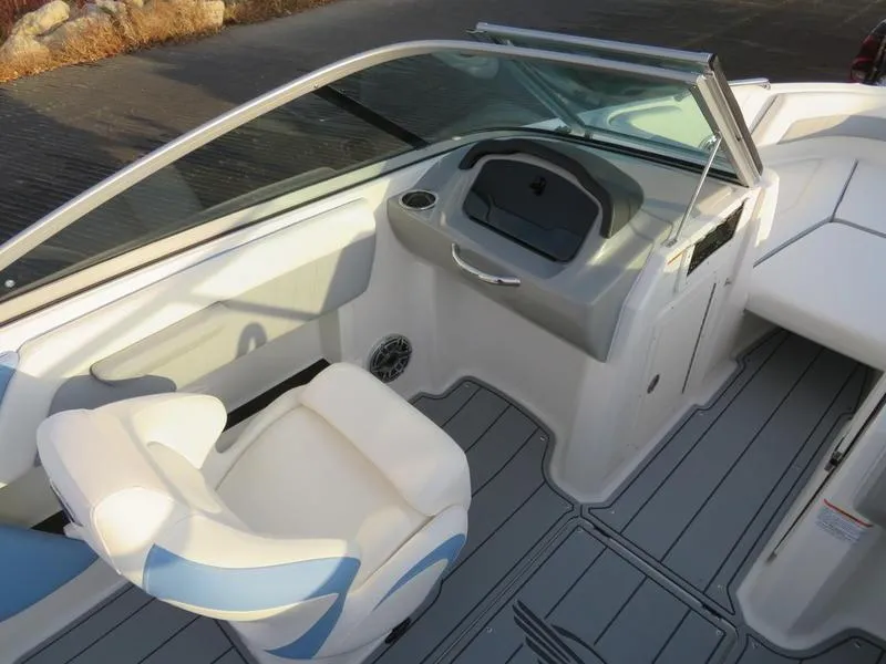 Slide: The Image of 2024 Chaparral 21 Surf boat interior with white and blue seating, dashboard, and steering wheel. - 12