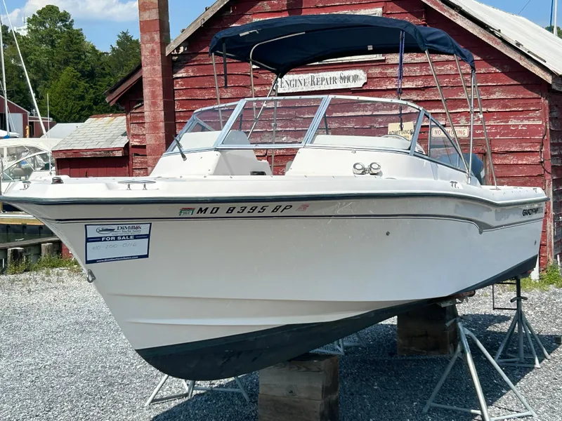Slide: The Image of 2003 Grady-White Tournament 225 boat on stands, for sale, in front of a red building. - 11
