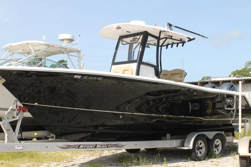 Slide: The Image of 2018 Sea Hunt 270 Gamefish boat on trailer, black hull, outdoor setting. - 0