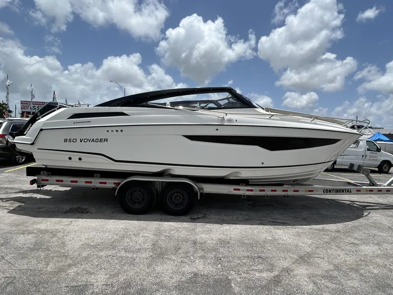 Slide: The Image of 2023 Skamander 850 Voyager boat with dual outboard motors in a marina. - 2