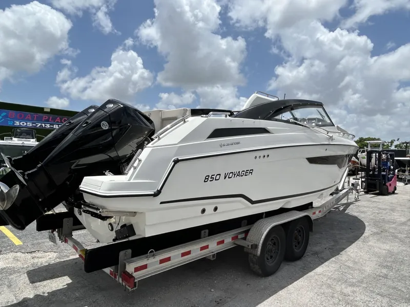 Slide: The Image of 2023 Skamander 850 Voyager boat on a trailer under a cloudy sky. - 25