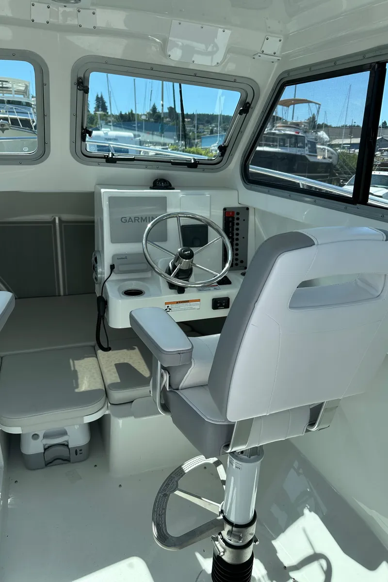 Slide: The Image of 2025 Parker 2420 Sport Cabin interior with steering wheel and navigation system. - 16