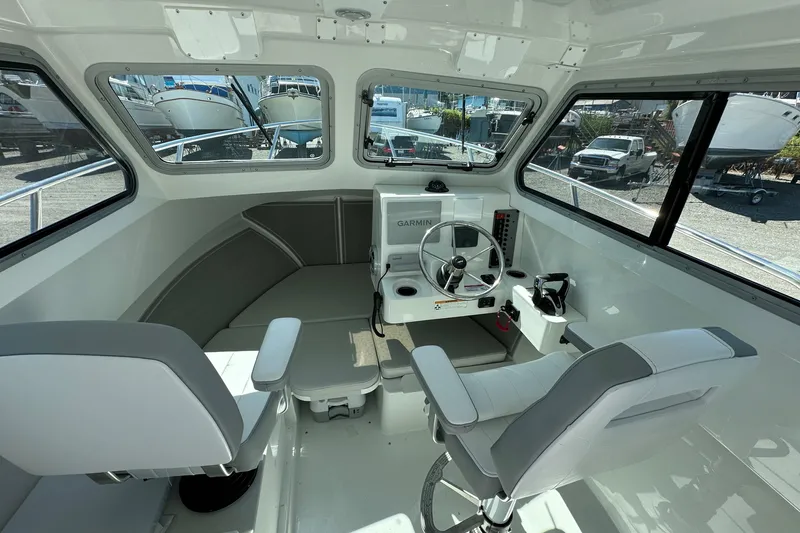 Slide: The Image of 2025 Parker 2420 Sport Cabin interior with steering wheel, seating, and windows. - 17