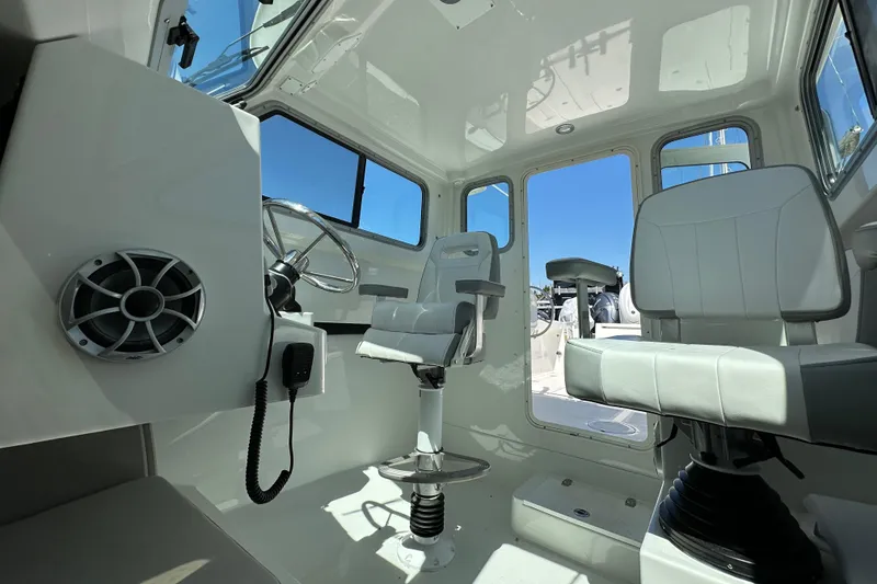 Slide: The Image of Interior of 2025 Parker 2420 Sport Cabin boat with modern seating and steering wheel. - 20