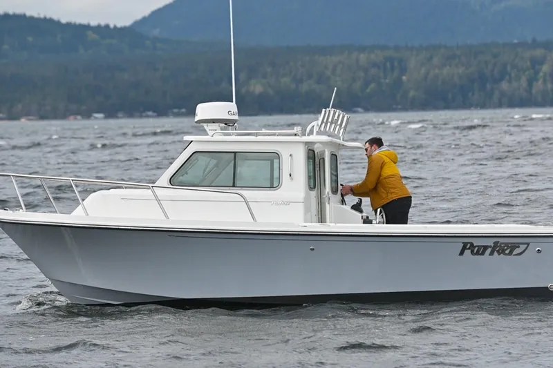 Slide: The Image of 2025 Parker 2420 Sport Cabin boat on water with person in yellow jacket. - 4