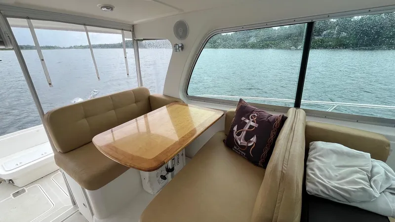 Slide: The Image of Interior of 2014 Back Cove 34 boat with cozy seating and table by a window. - 15