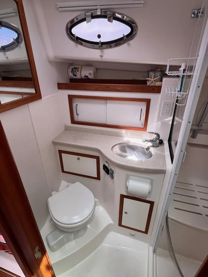 Slide: The Image of 2014 Back Cove 34 yacht bathroom with sink, toilet, and storage cabinets. - 30