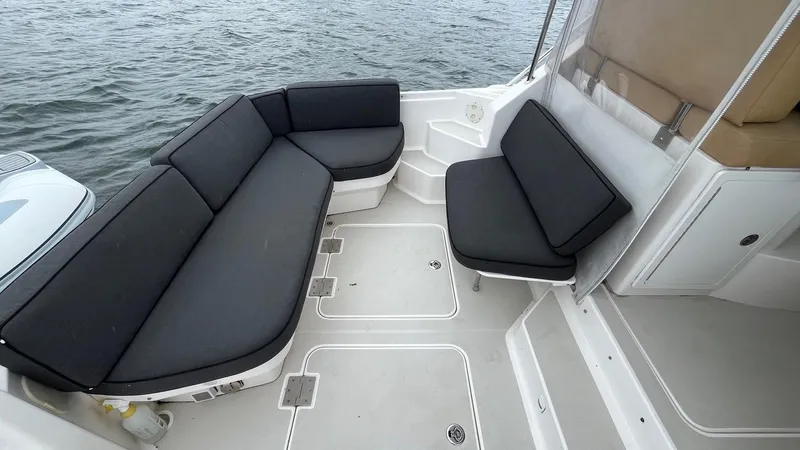 Slide: The Image of 2014 Back Cove 34 boat with spacious seating area and black cushions. - 8