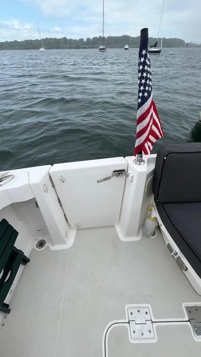 Slide: The Image of 2014 Back Cove 34 boat deck with American flag, overlooking calm waters. - 9