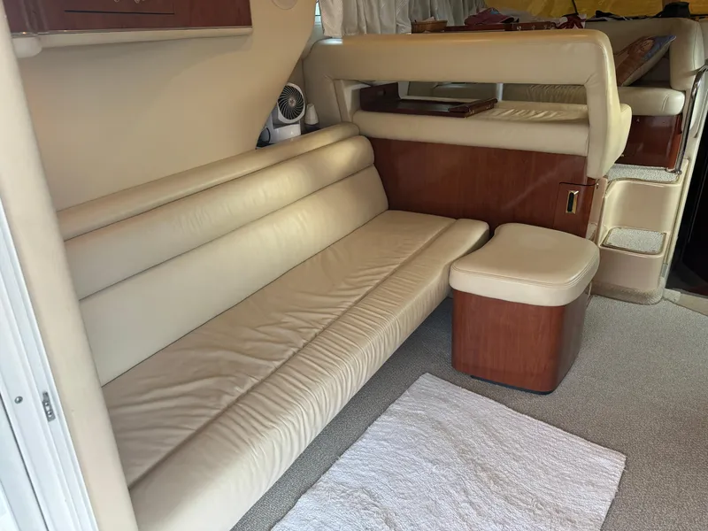 Slide: The Image of 2003 Sea Ray 400 Sedan Bridge interior with beige leather seating and wooden accents. - 17