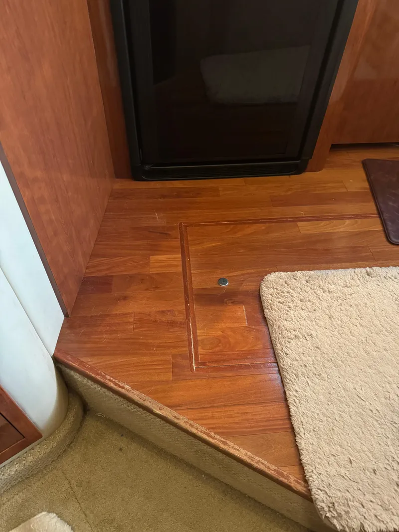 Slide: The Image of Interior of 2003 Sea Ray 400 Sedan Bridge with wooden flooring and beige carpet. - 23