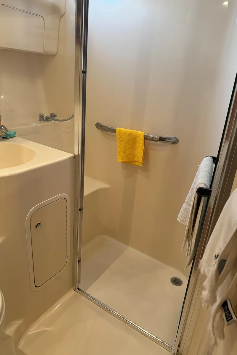 Slide: The Image of 2003 Sea Ray 400 Sedan Bridge bathroom with shower and towels. - 26