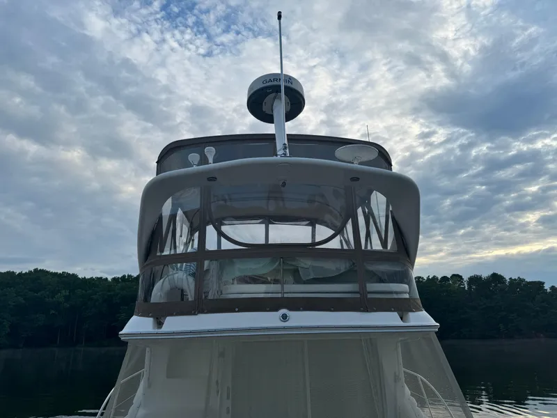 Slide: The Image of 2003 Sea Ray 400 Sedan Bridge yacht on calm water under cloudy sky. - 4