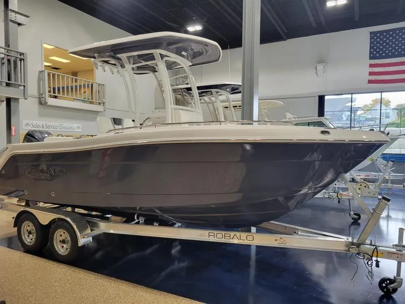 Slide: The Image of 2025 Robalo 222 CC boat on trailer in showroom. - 1