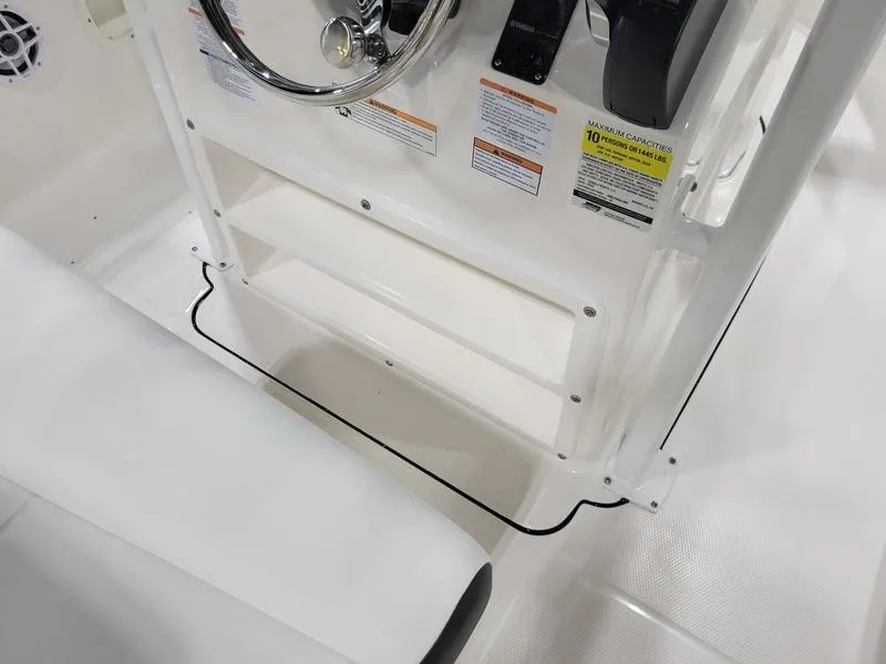 Slide: The Image of 2025 Robalo 222 CC boat console with steering wheel and seating area. - 12