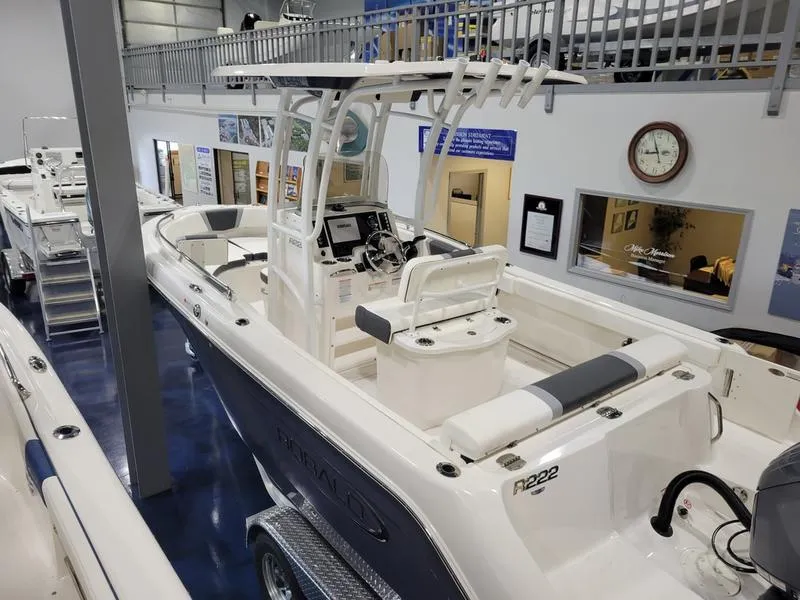 Slide: The Image of 2025 Robalo 222 CC boat in showroom, featuring sleek design and modern controls. - 13