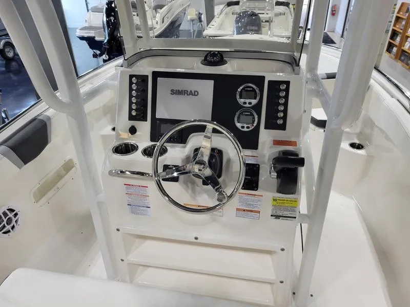 Slide: The Image of 2025 Robalo 222 CC boat console with steering wheel and Simrad display. - 14