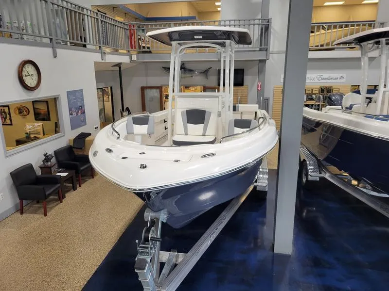 Slide: The Image of 2025 Robalo 222 CC boat displayed indoors on a trailer. - 17