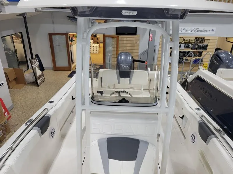 Slide: The Image of 2025 Robalo 222 CC boat interior with helm and seating in showroom. - 7
