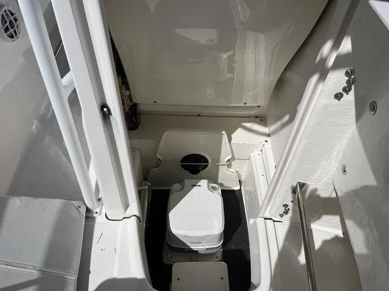 Slide: The Image of 2025 Robalo R 202 EX boat interior with compact marine toilet. - 11