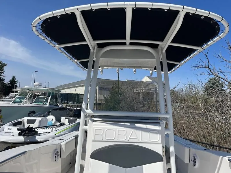 Slide: The Image of 2025 Robalo R 202 EX boat with T-top canopy, docked outdoors. - 4