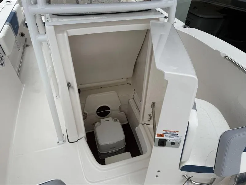 Slide: The Image of 2025 Robalo R 200 boat interior with compact marine toilet. - 10