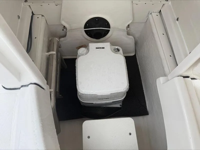 Slide: The Image of 2025 Robalo R 200 boat interior with portable toilet setup. - 11